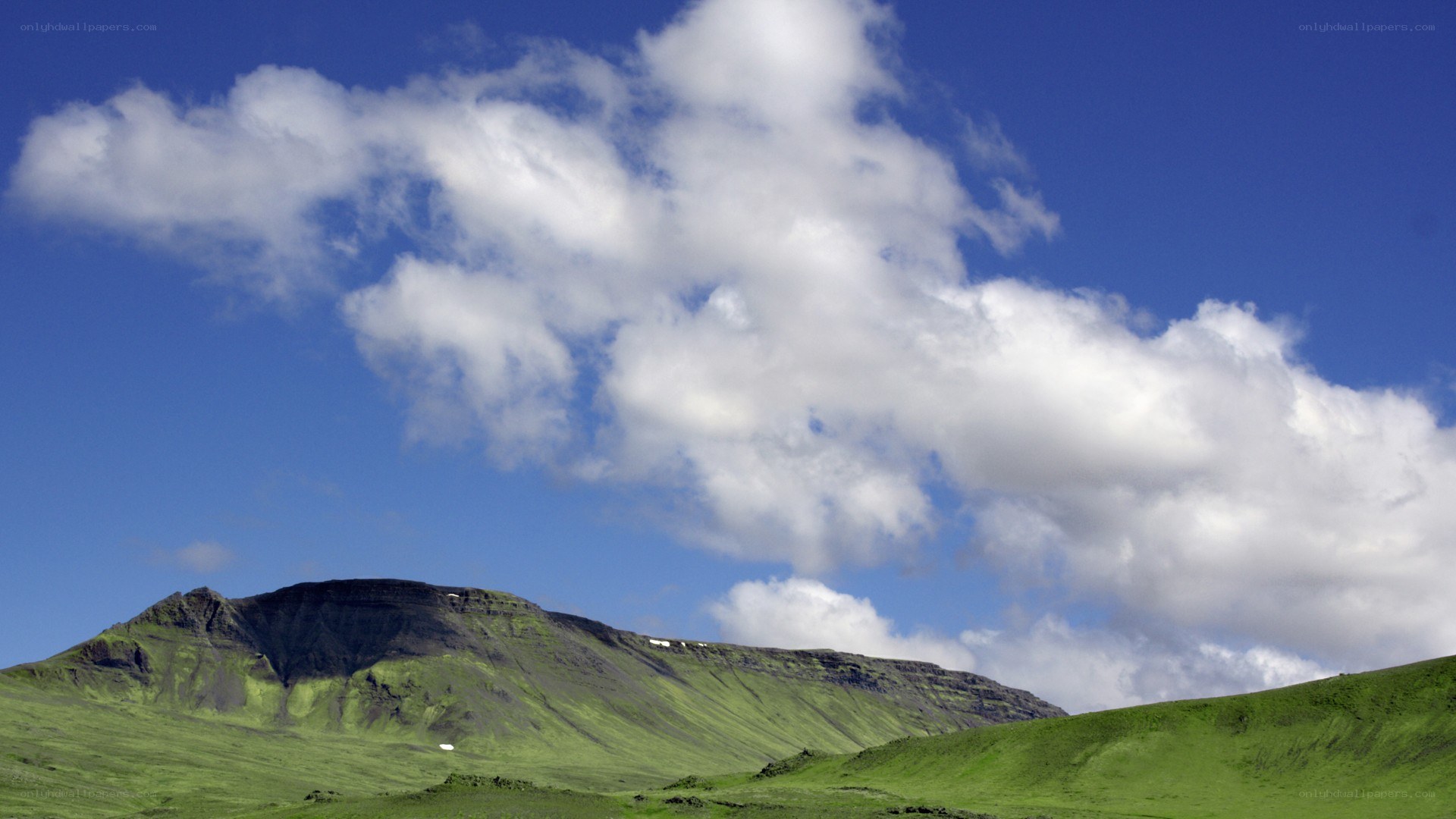 Green hills under blue sky