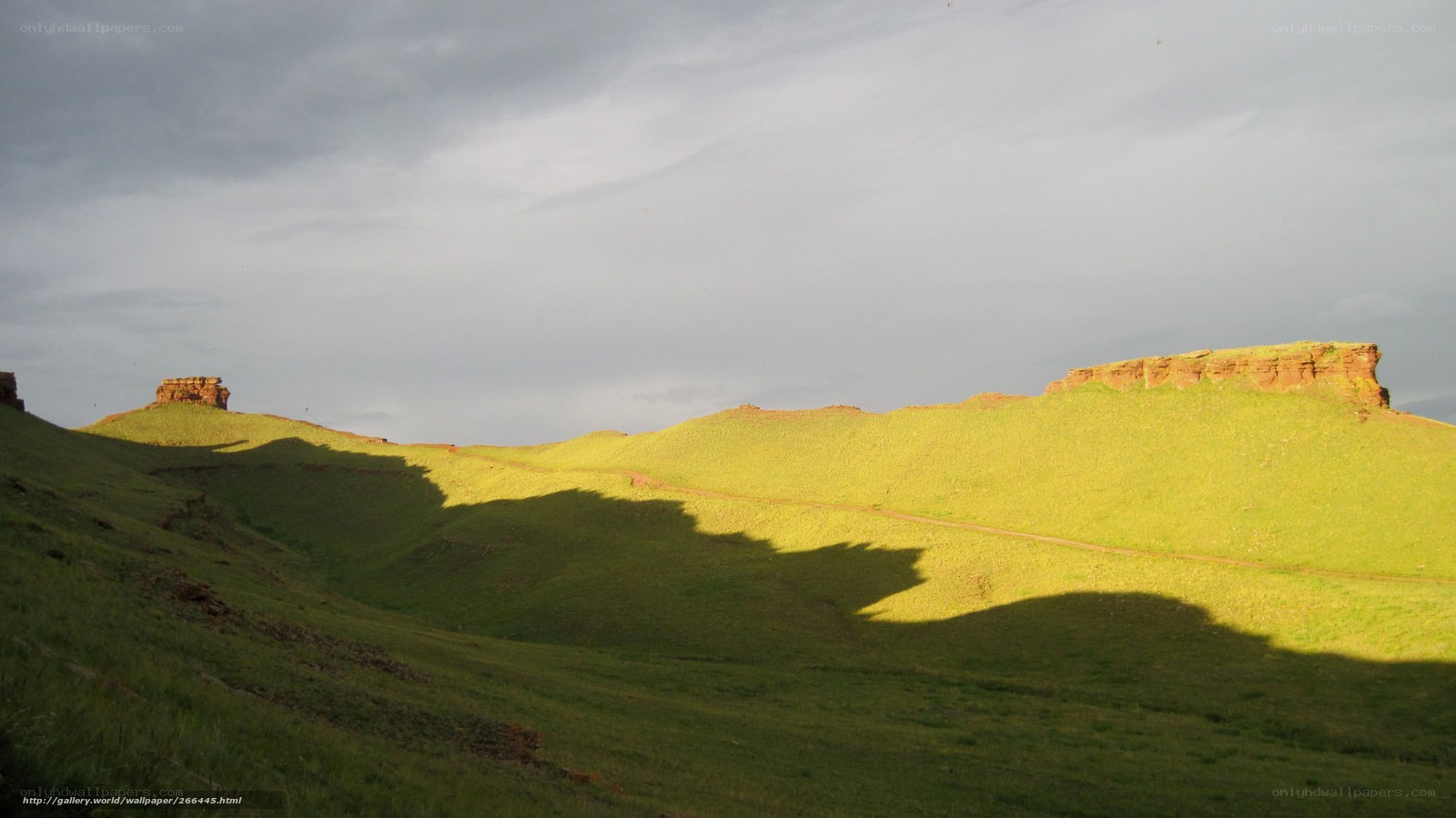 Green hills under cloudy sky