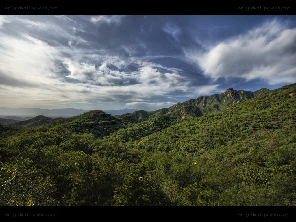 Green hills under cloudy sky