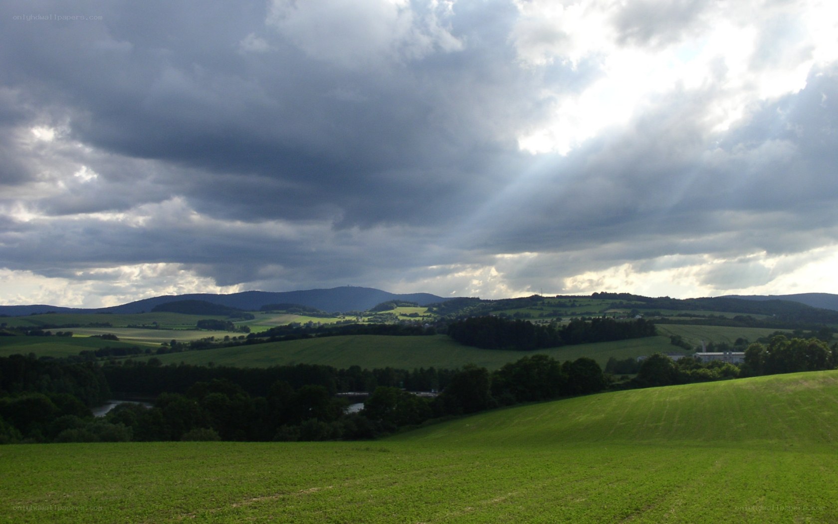 Green hills under cloudy sky