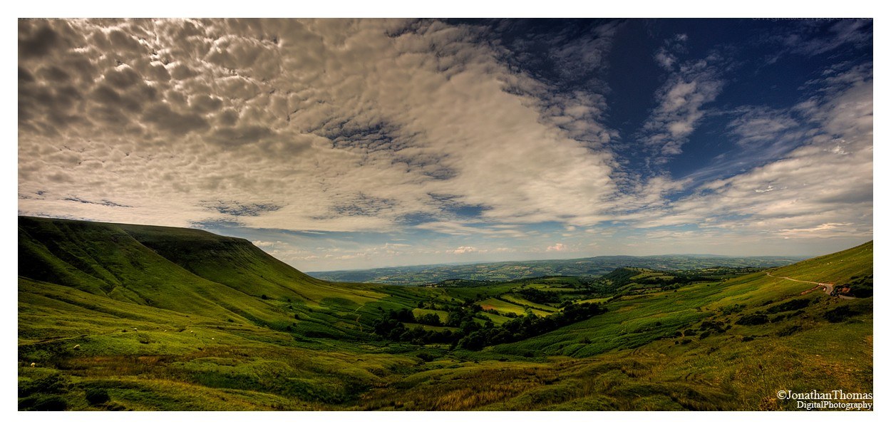 Green hills under cloudy sky