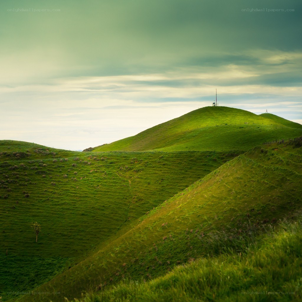 Green hills under cloudy sky