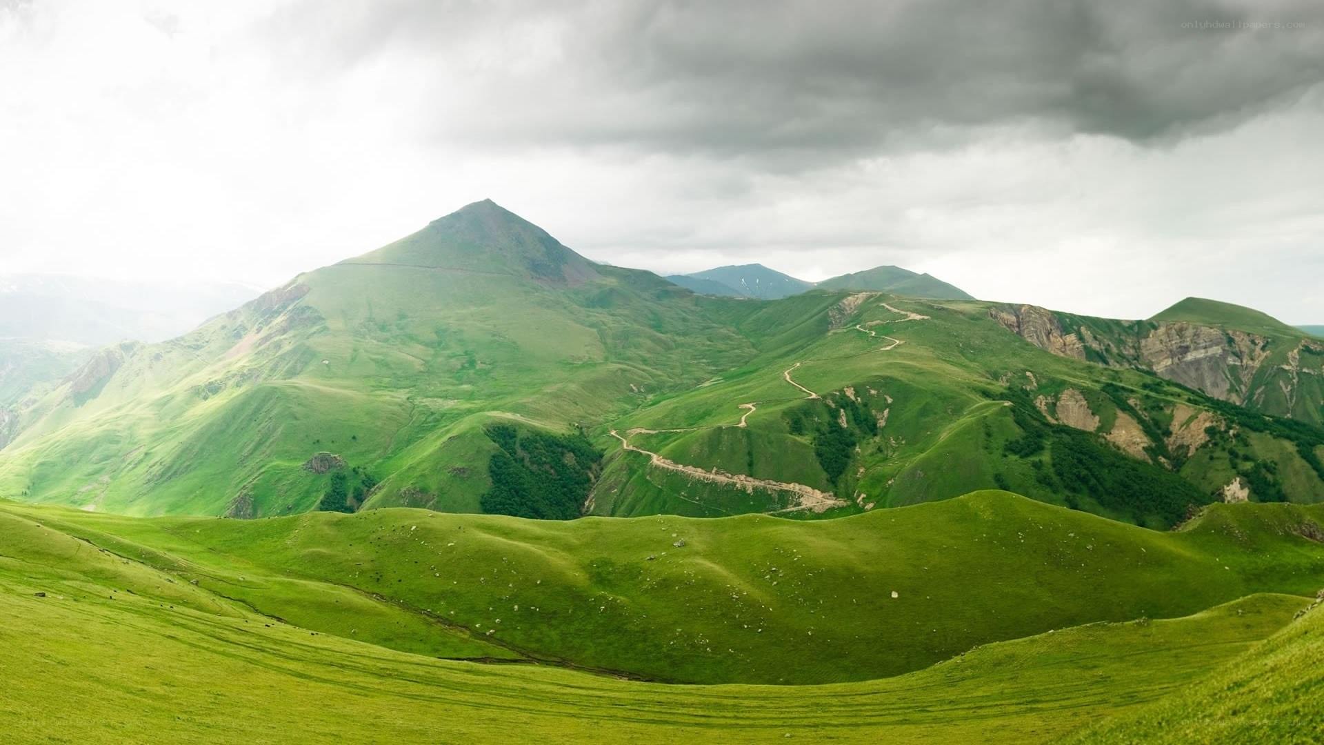 Green hills under cloudy sky