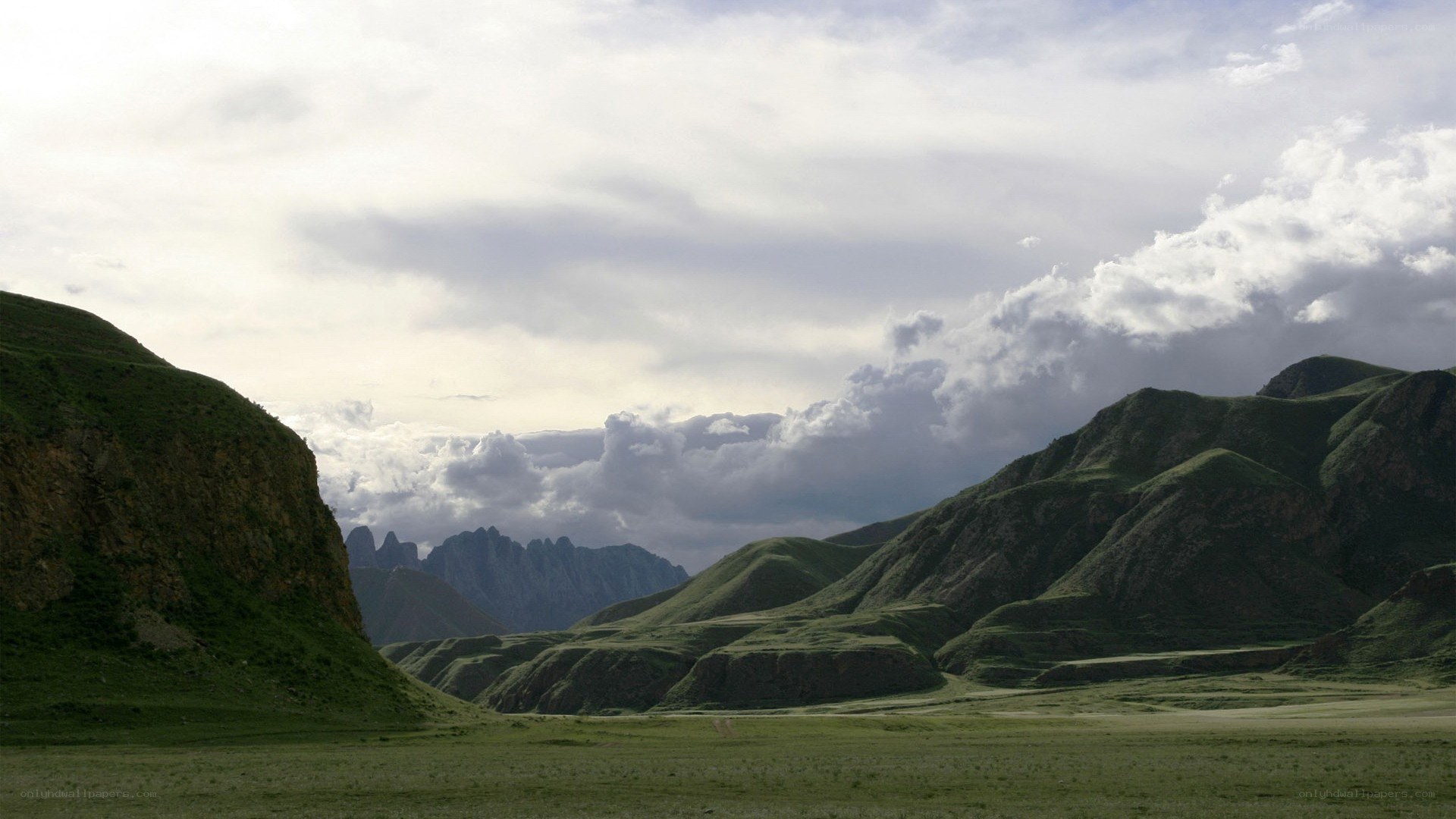 green hills under cloudy sky
