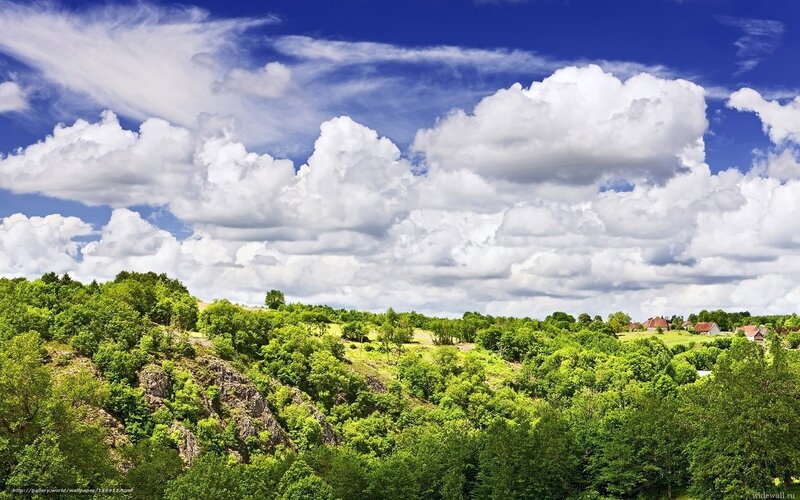 Green hills under cloudy sky