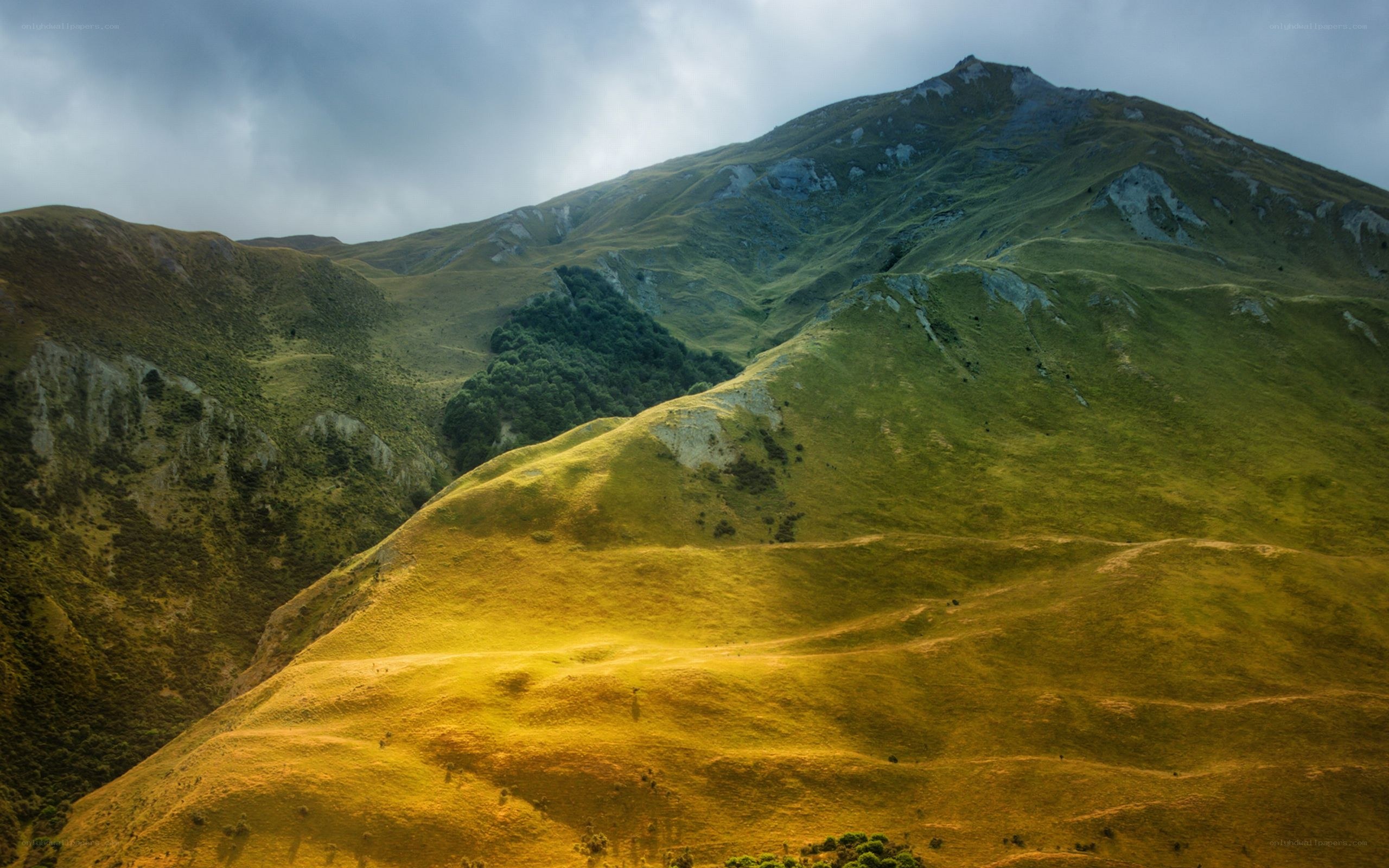 Green hills under cloudy sky