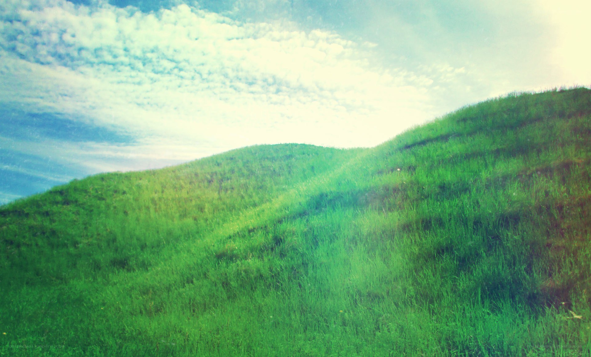 Green hills under cloudy sky
