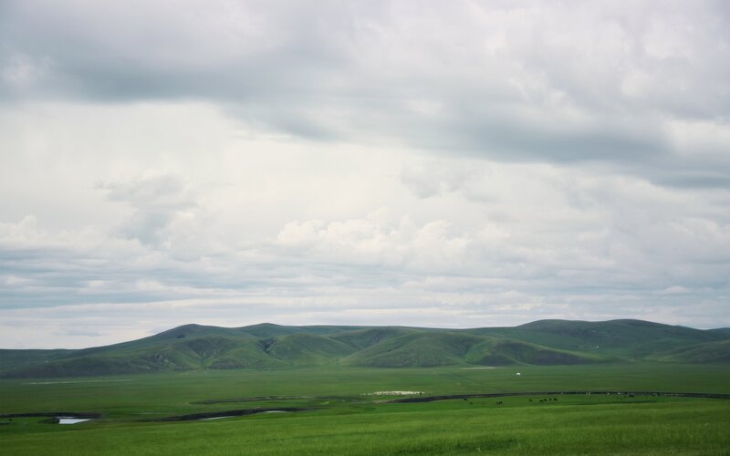 Green hills under cloudy sky
