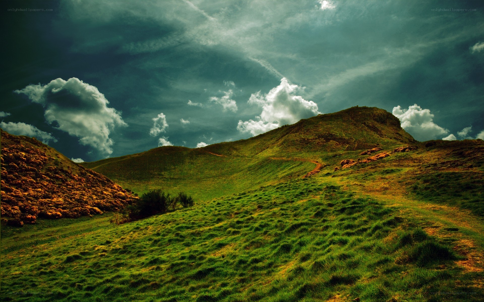 Green hills under cloudy sky