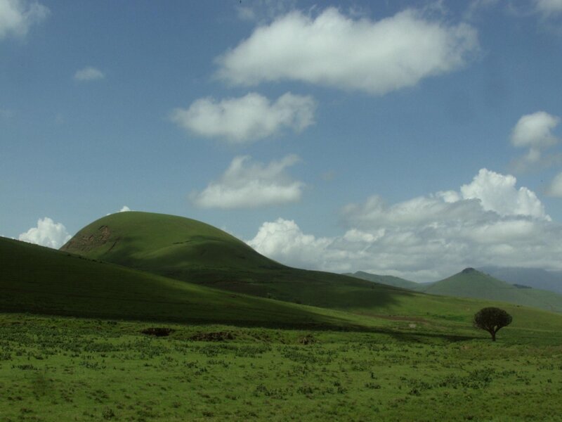 Green Hills under Cloudy Sky — Serene, Afternoon, Photograph