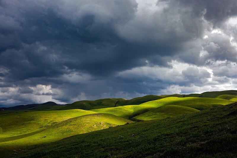 Green Hills Under Stormy Sky