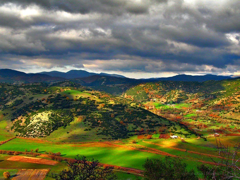 Green hills under stormy sky