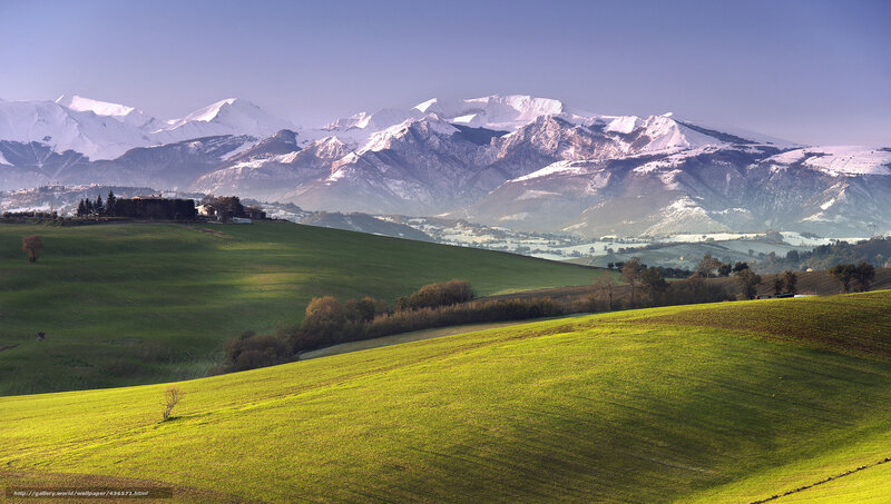 Green hills with snow-capped mountains