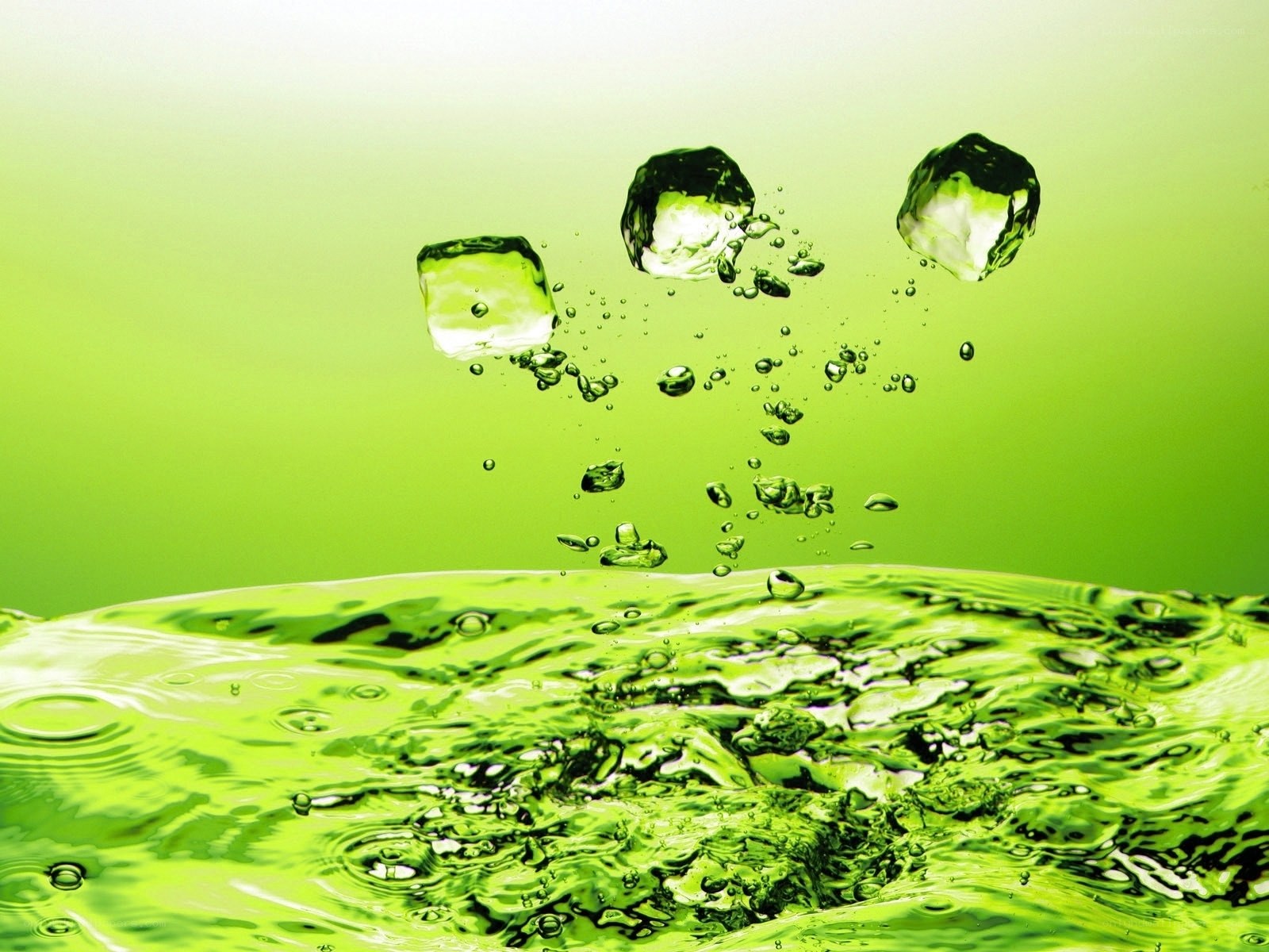 green ice cubes falling into water