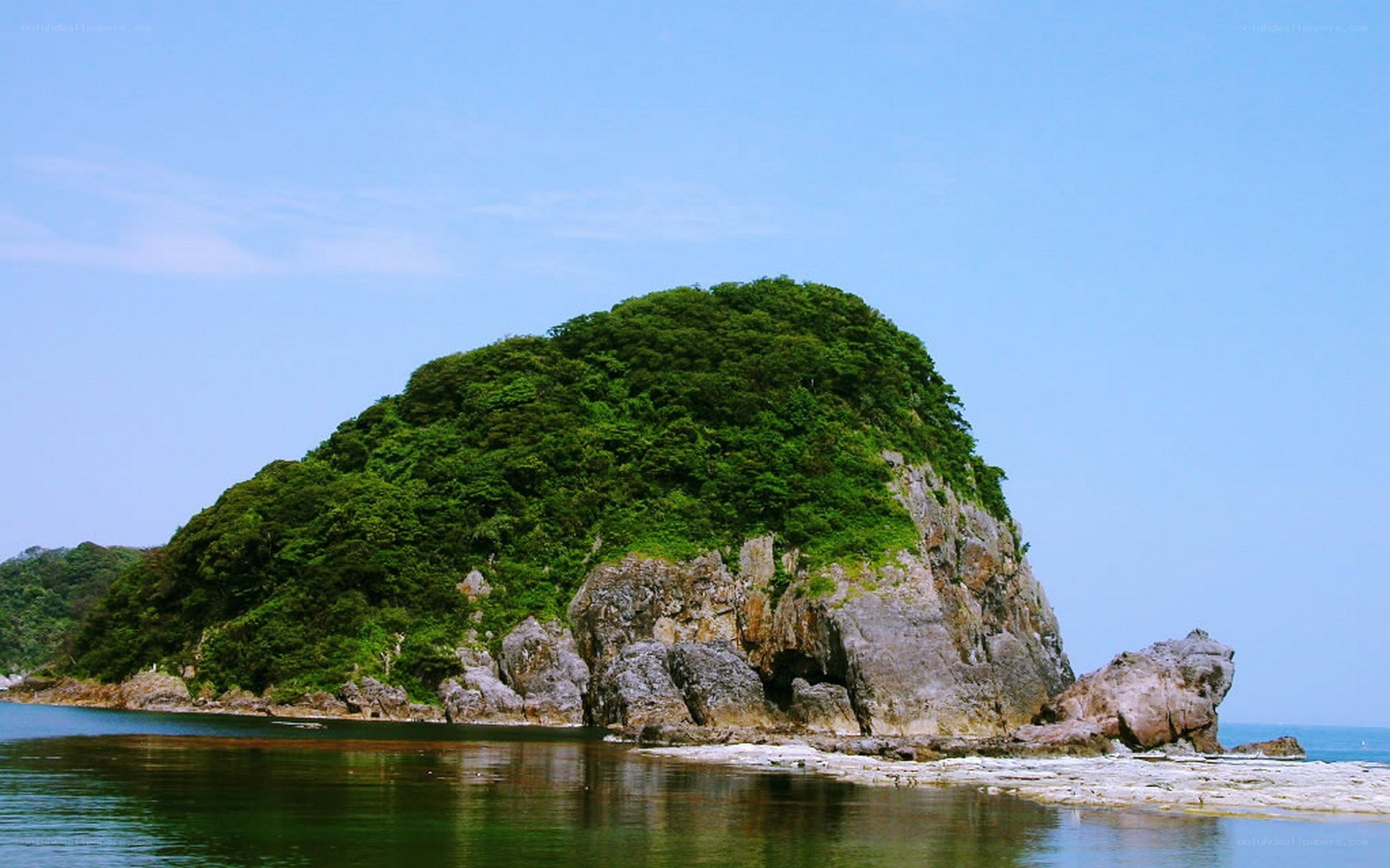 Green island in calm sea