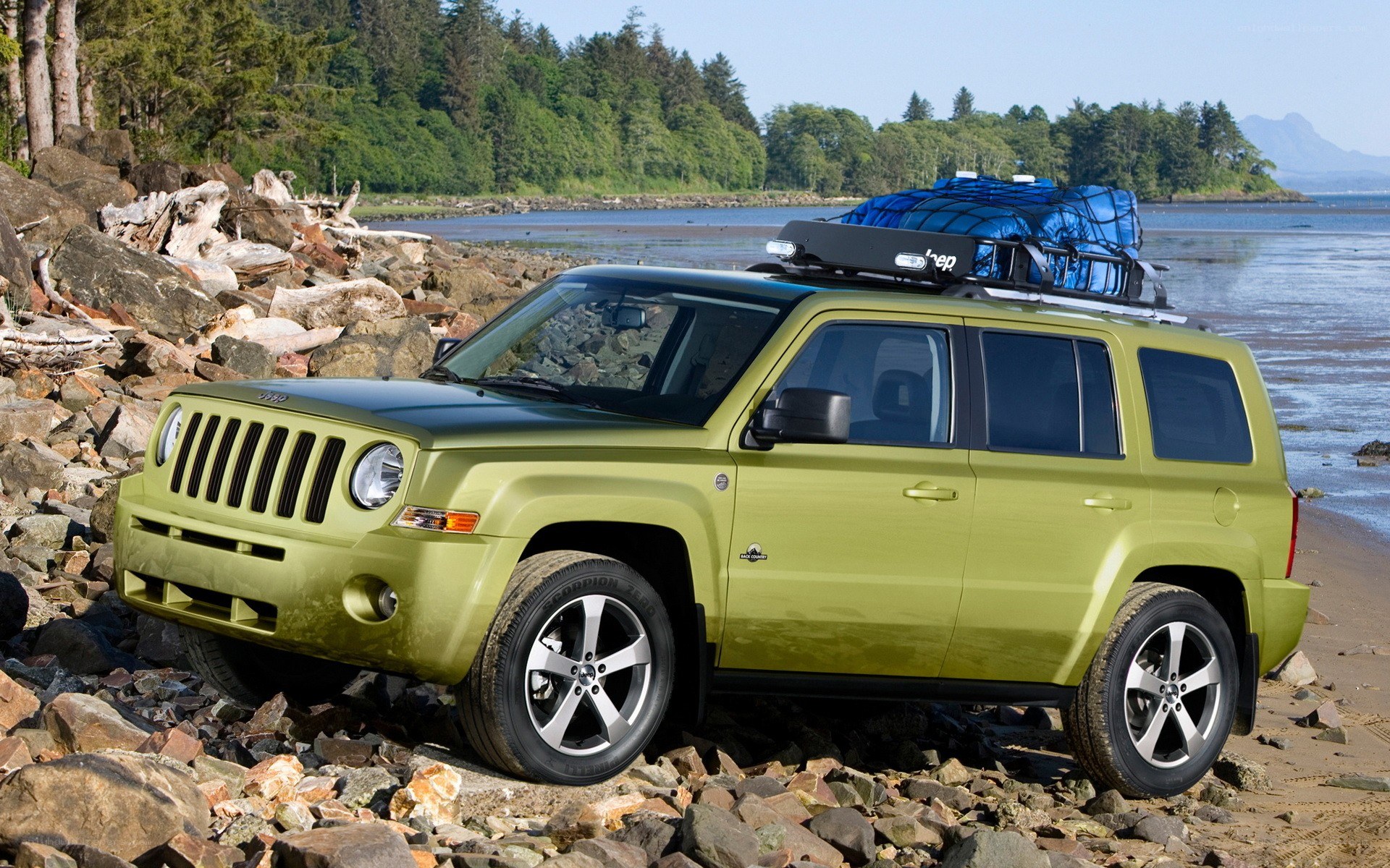 Green Jeep on rocky beach
