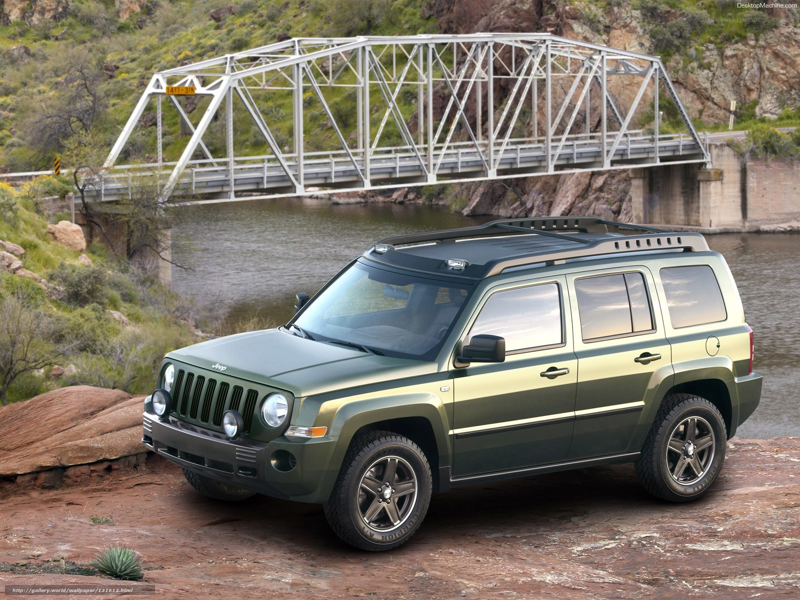 Green Jeep Patriot by a river
