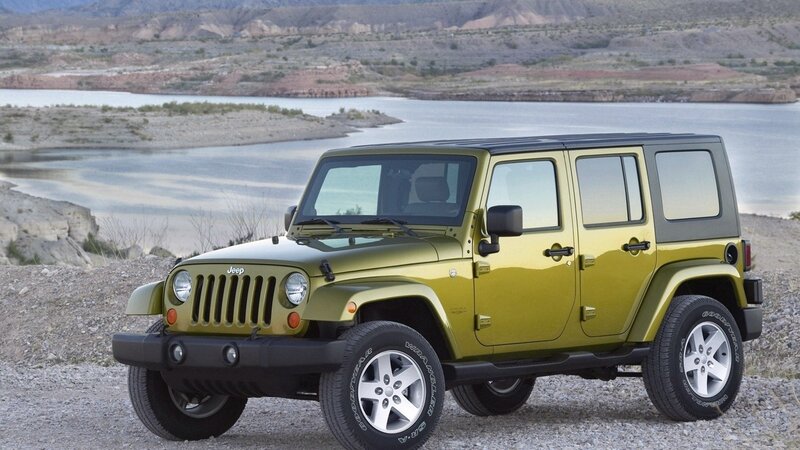 Green Jeep Wrangler by a lake