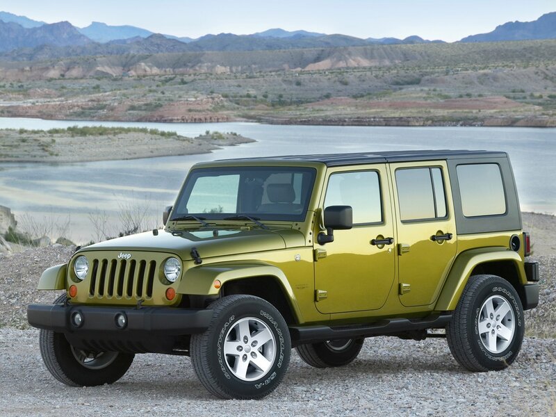 Green Jeep Wrangler by a lake