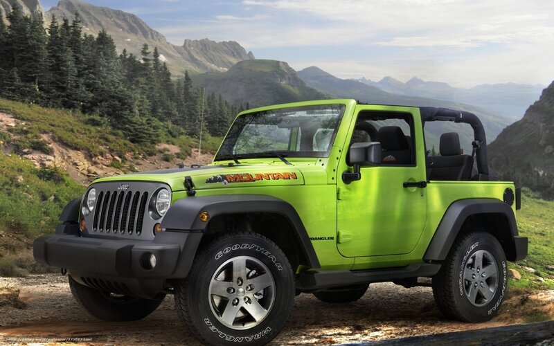 Green Jeep Wrangler in mountains