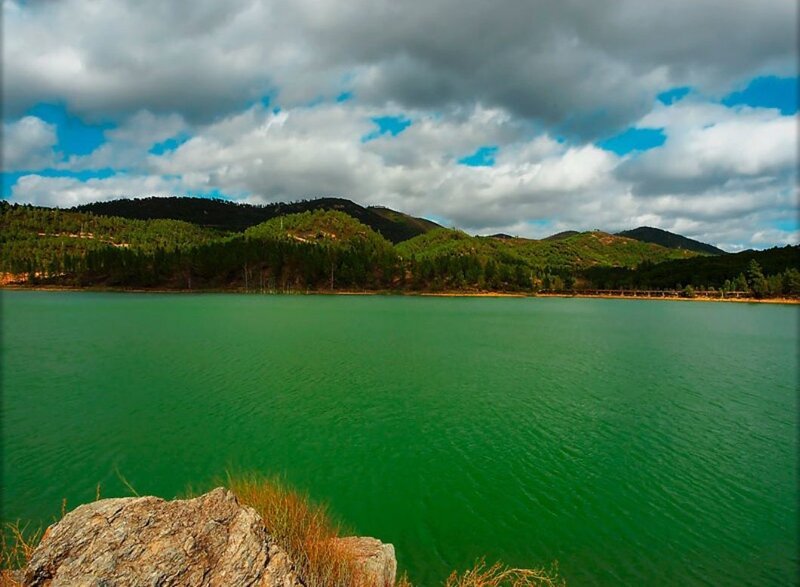 green lake with forested hills