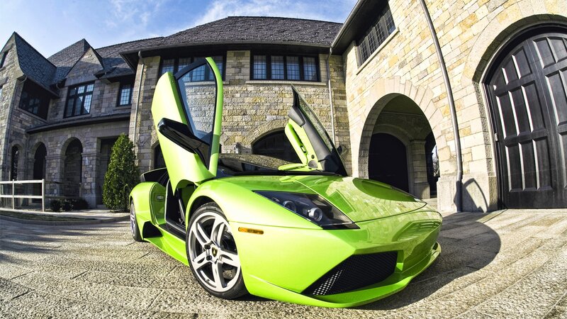 Green Lamborghini in front of mansion