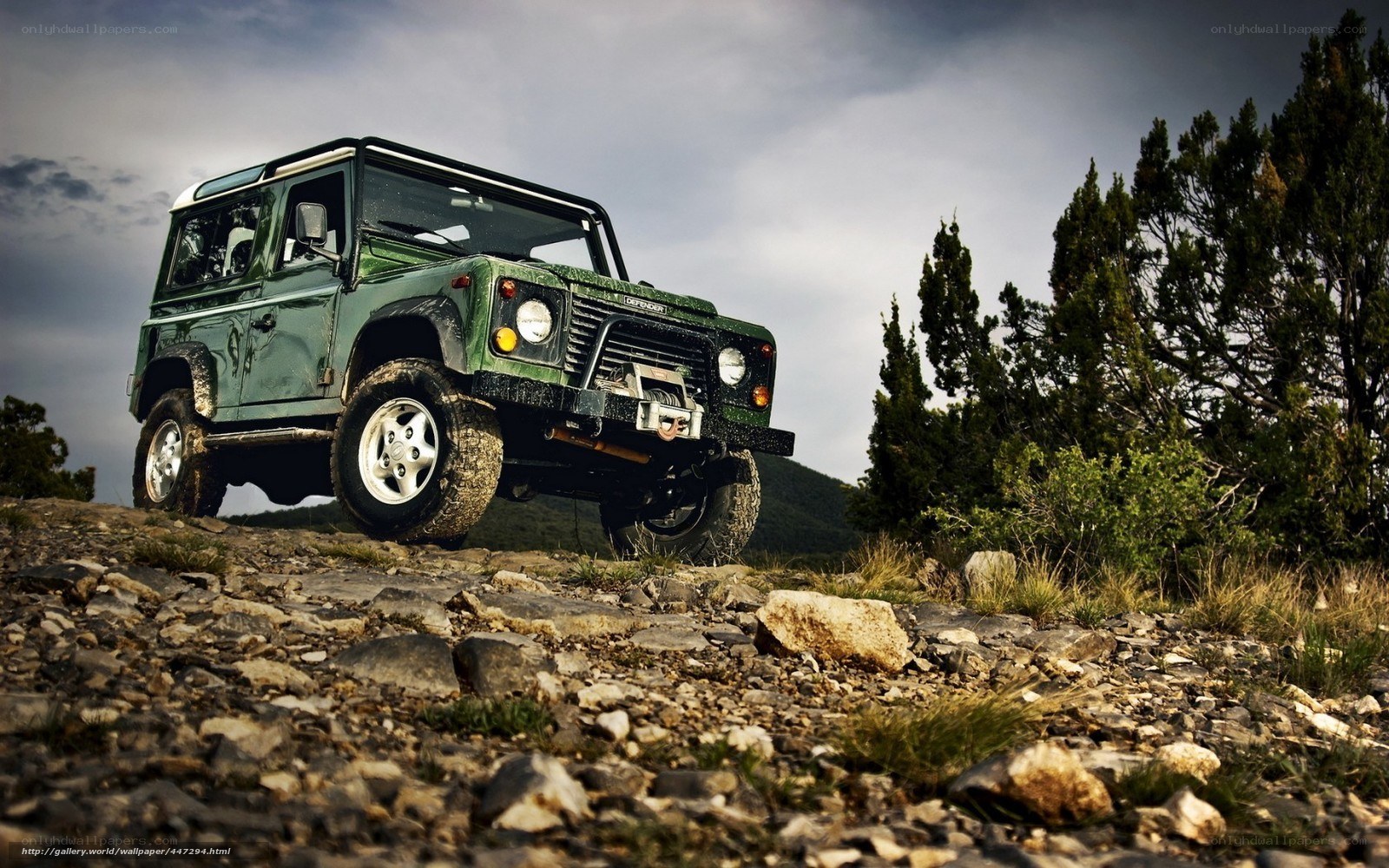 Green Land Rover on rocky terrain