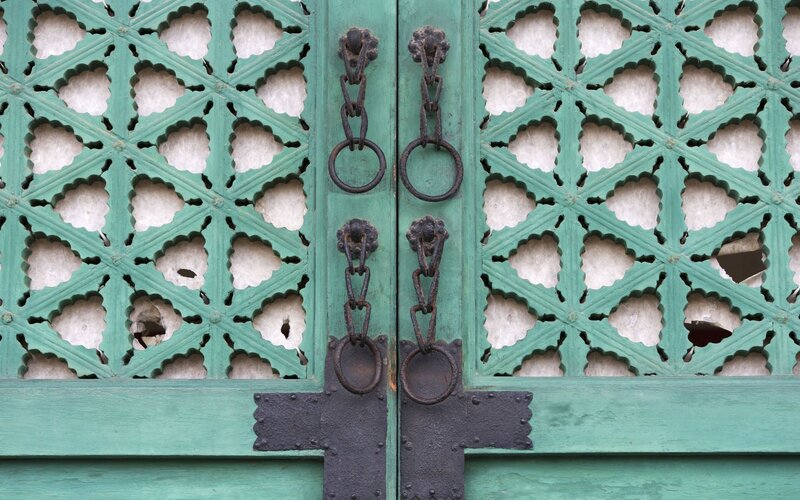 green lattice door with iron hardware