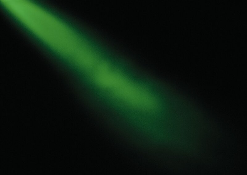 green light beam in darkness