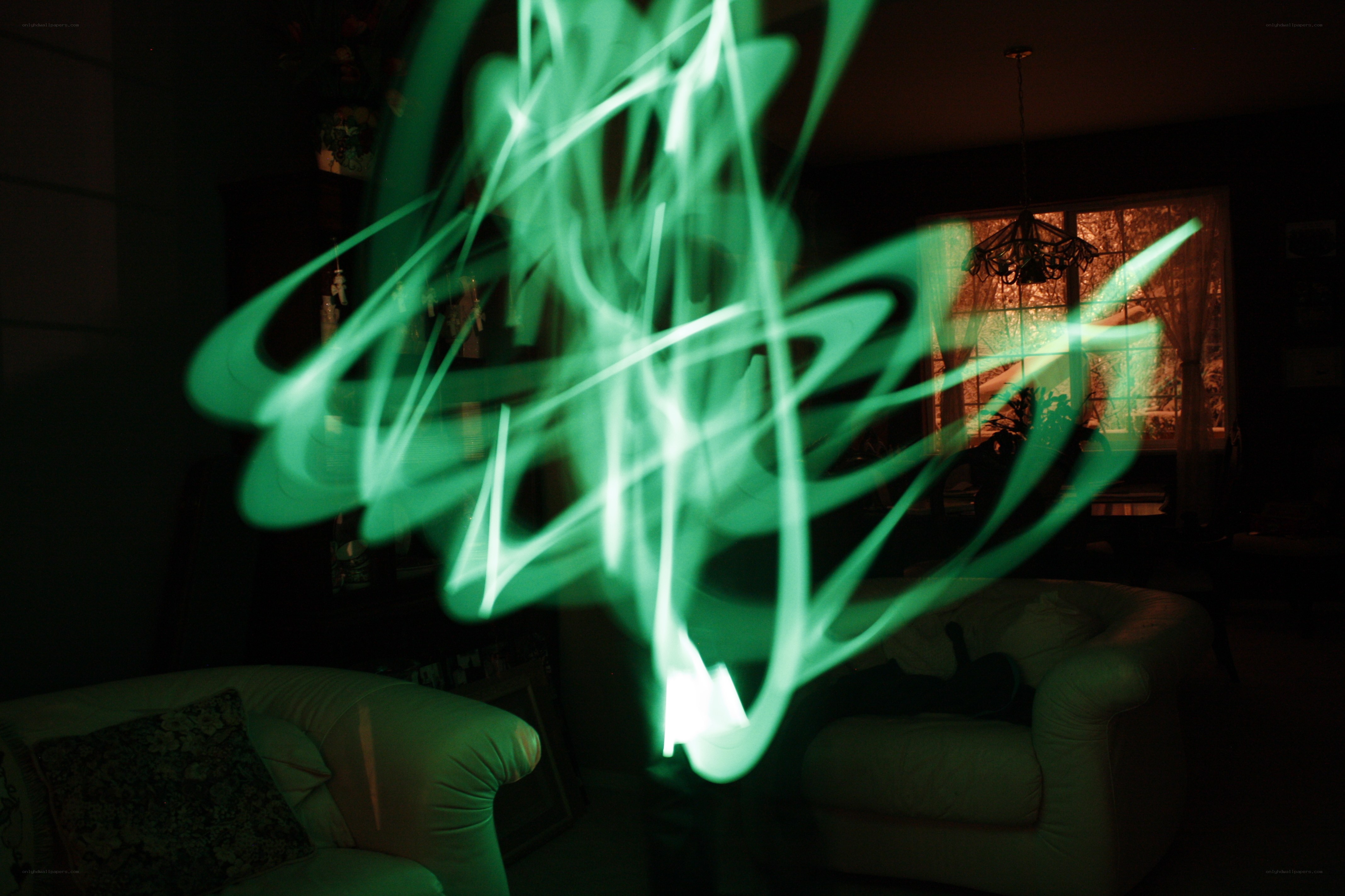 Green light trails in a dark room