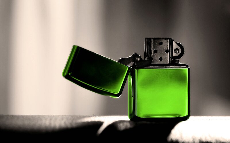 green lighter on dark surface