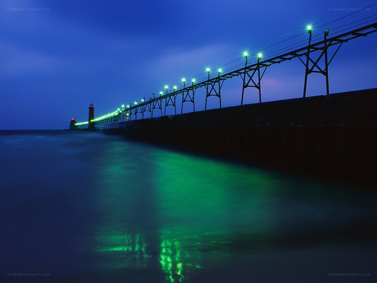 Green lights on a pier at night