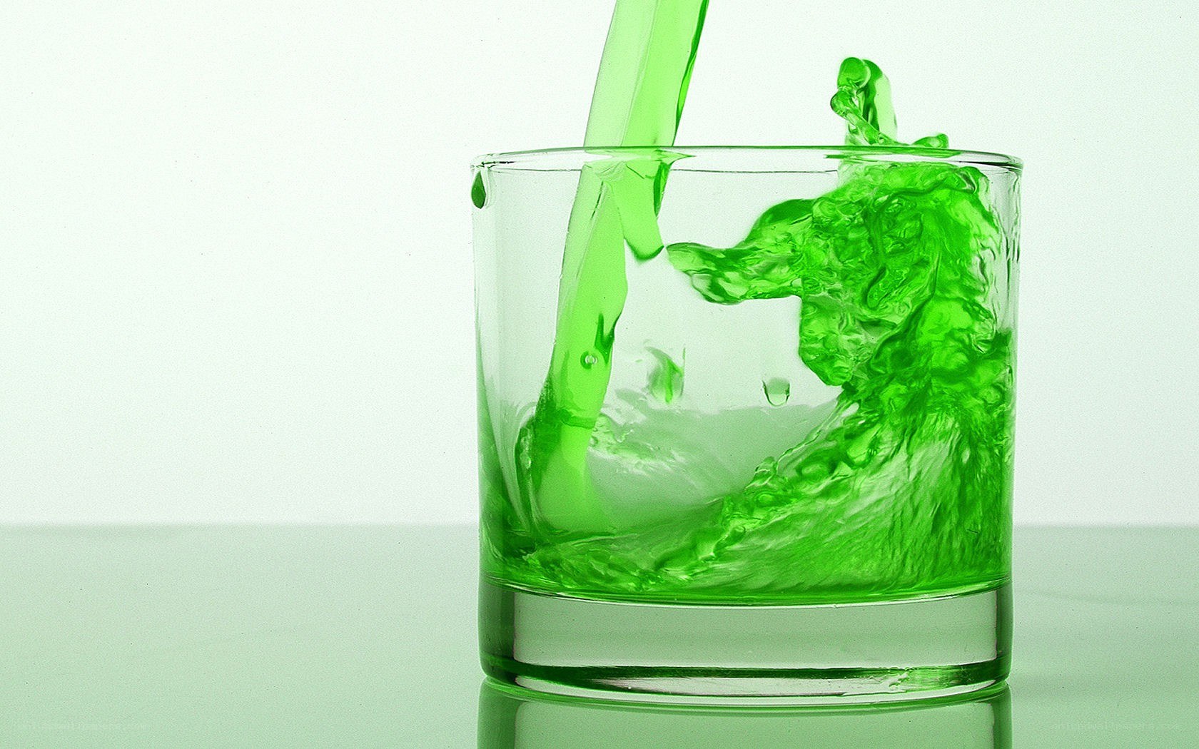 green liquid pouring into glass