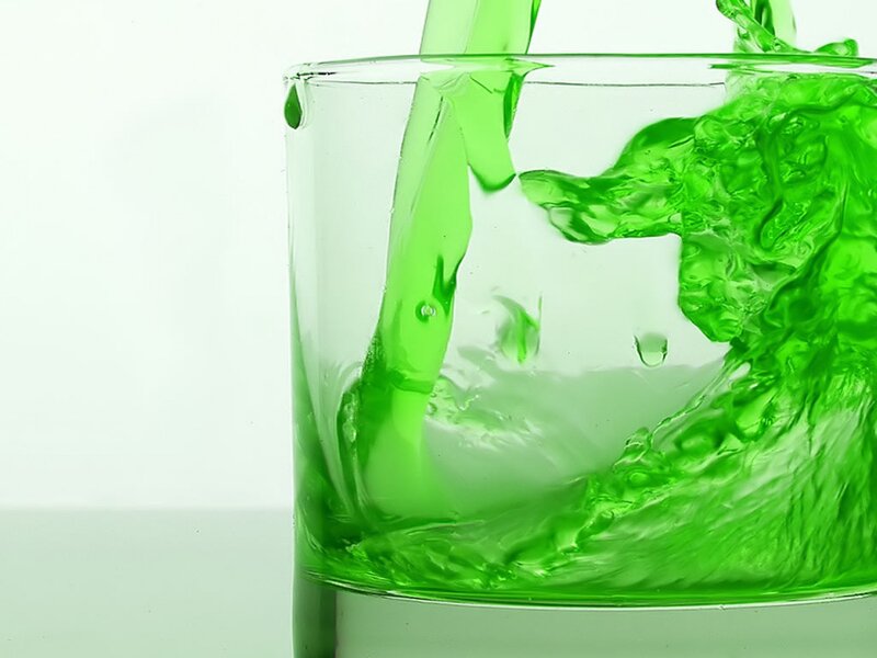 green liquid pouring into glass