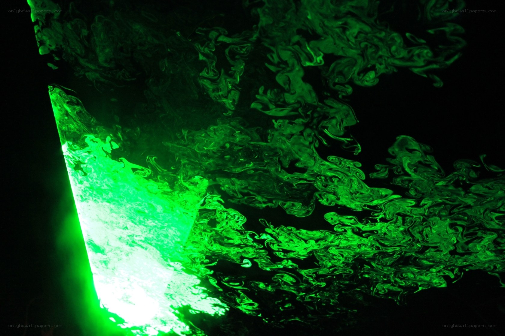 green liquid swirling in darkness