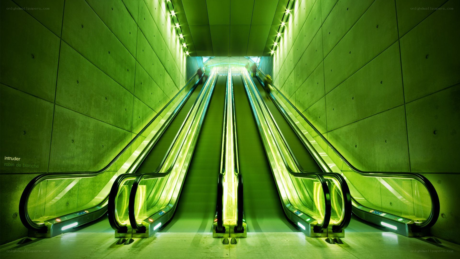 Green-lit escalators in a tunnel