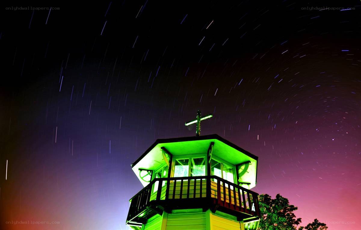 Green-lit tower under star trails