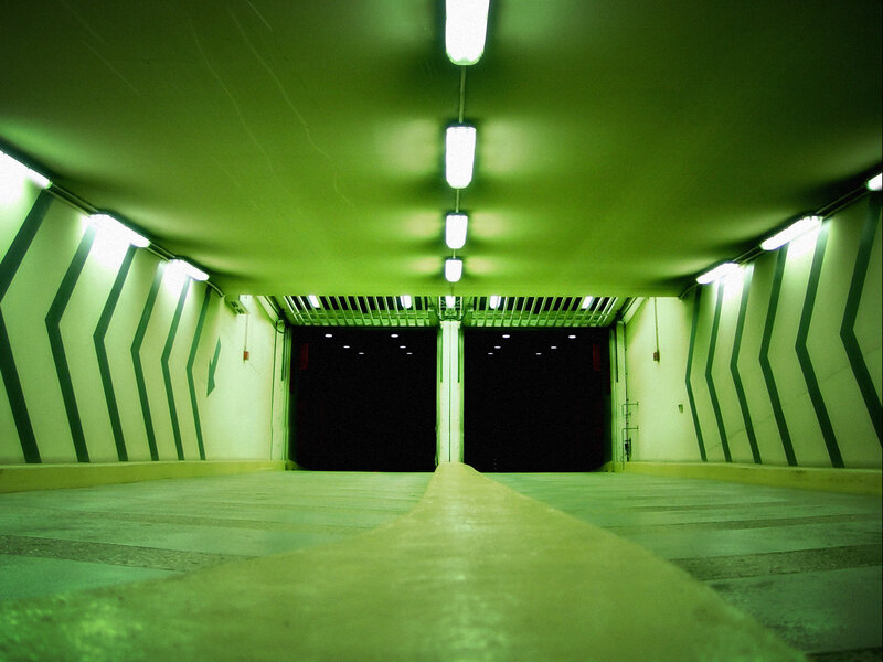 green-lit tunnel with arrows