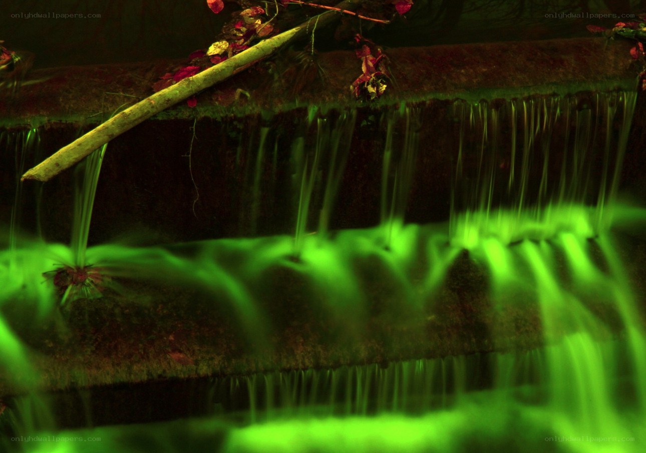 green-lit waterfall at night
