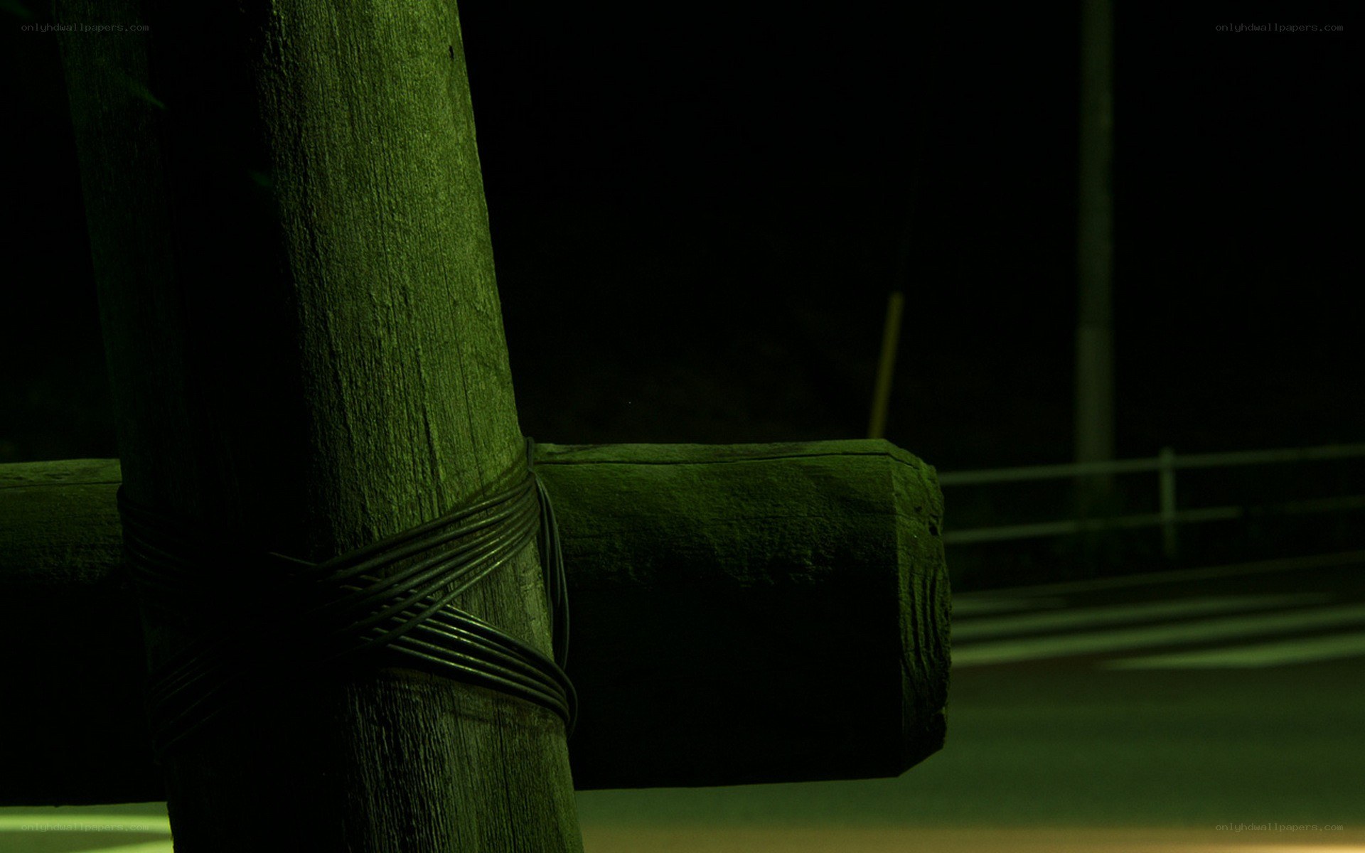 green-lit wooden post at night