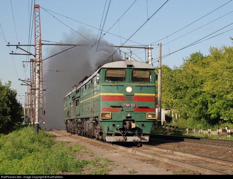 Green locomotive emitting smoke