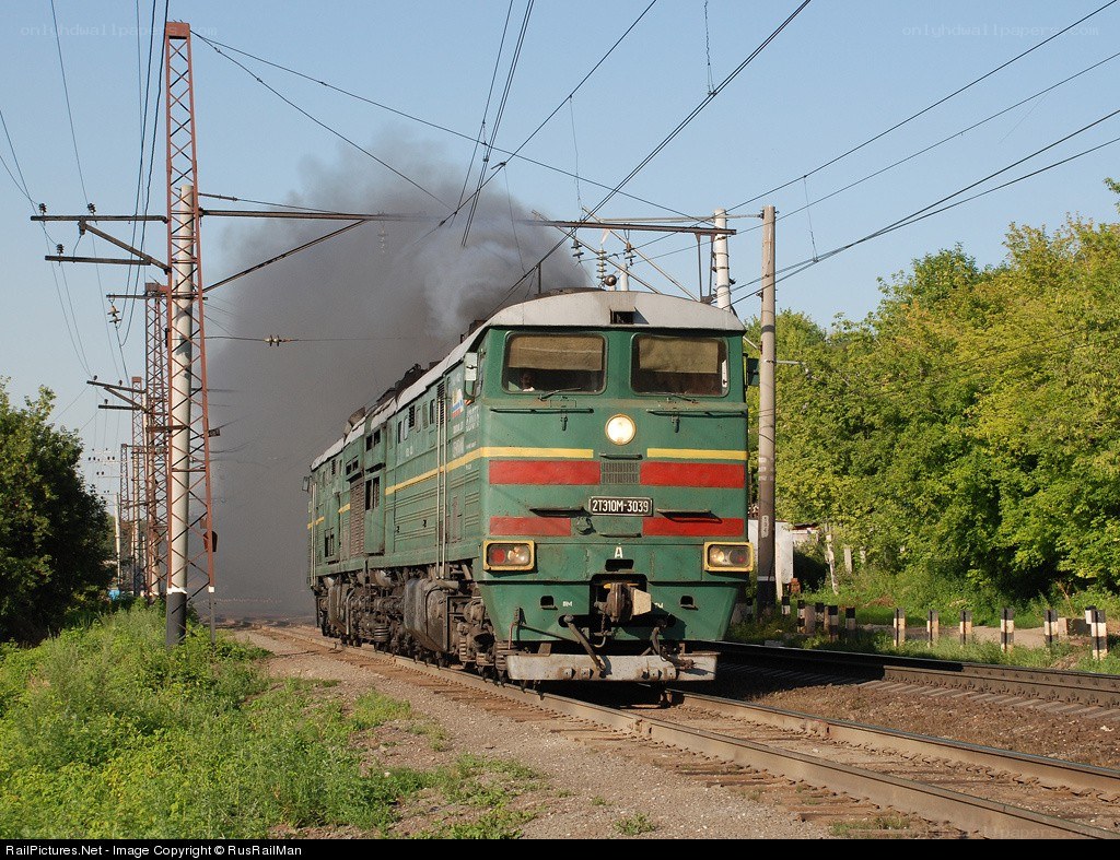 Green locomotive emitting smoke