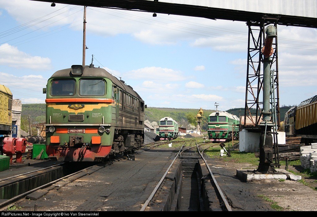 Green locomotives at a rail yard
