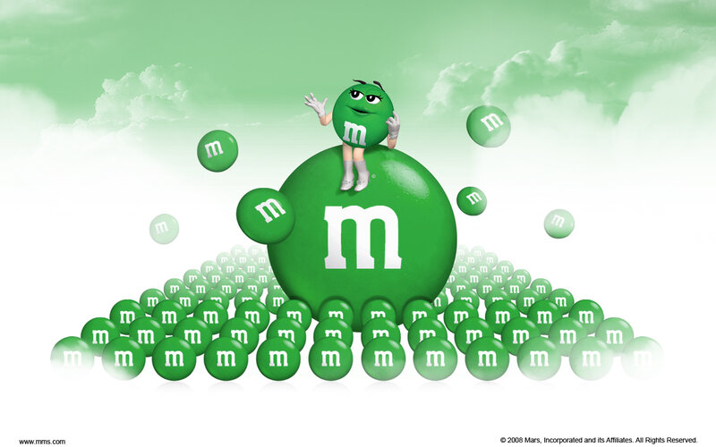 Green M&M character on a candy mound