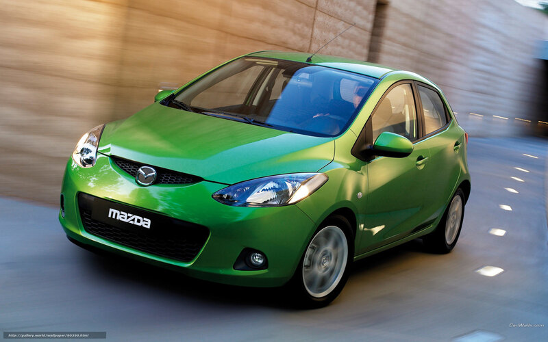 Green Mazda 2 in motion