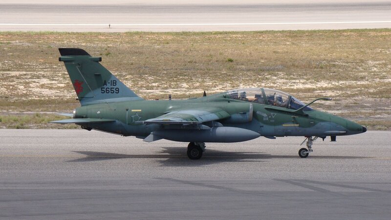 Green military jet on runway