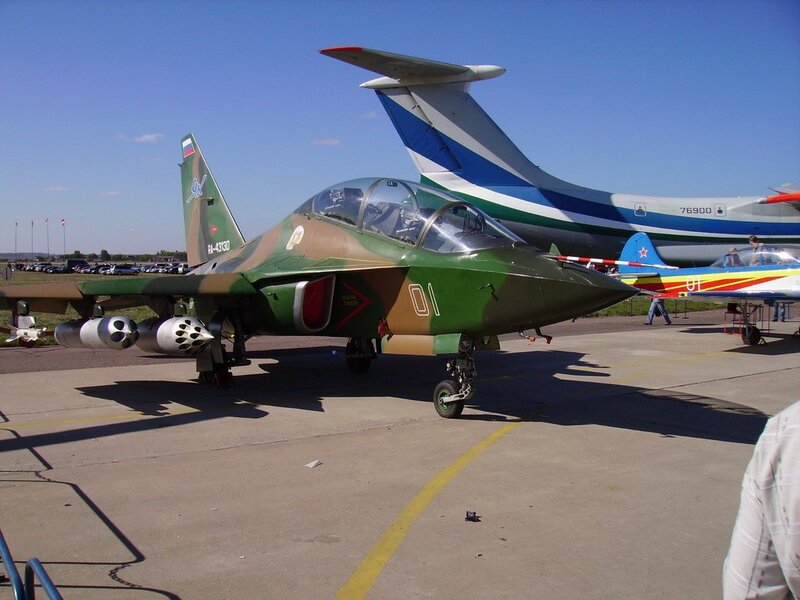 Green military jet on tarmac