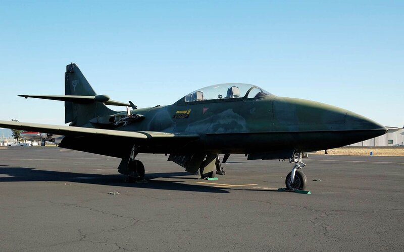 Green military jet on tarmac