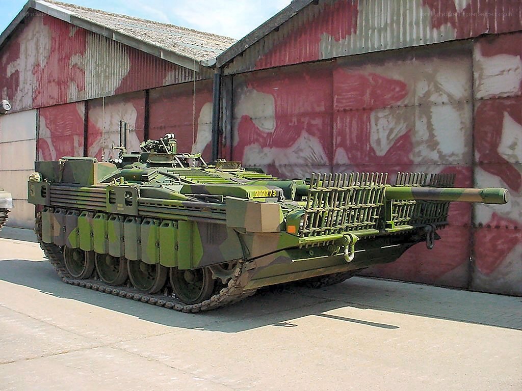 Green military tank outside building