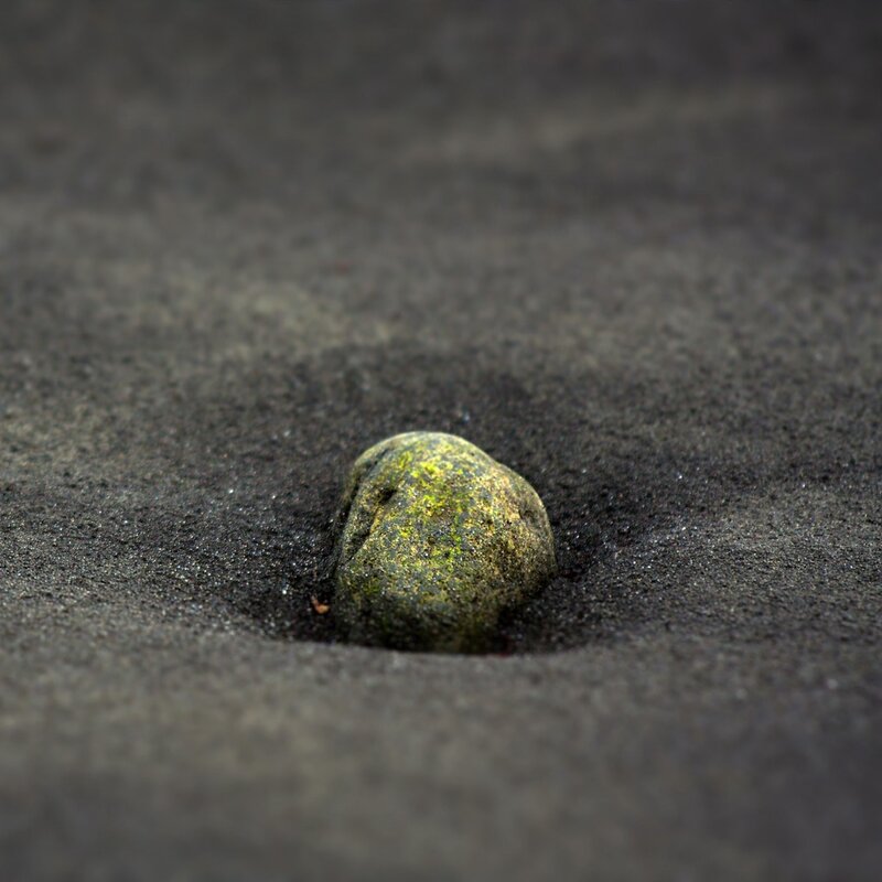 green mossy stone in sand